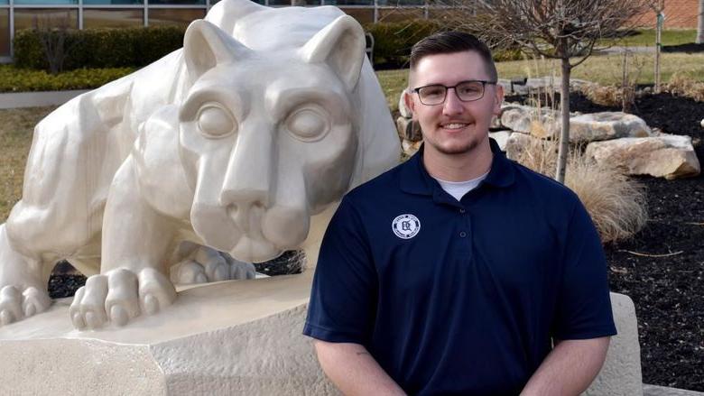 Lukas Salvo with the Lion Shrine on the campus of 365英国上市杜波依斯分校