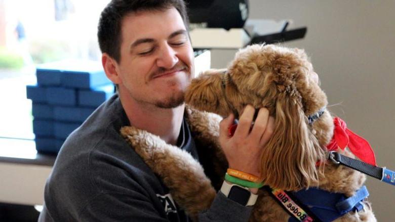 Penn State DuBois third-year student Jeff Romano enjoys the comfort a therapy dog gives him during one of the events of De-Stress Fest at Penn State DuBois.