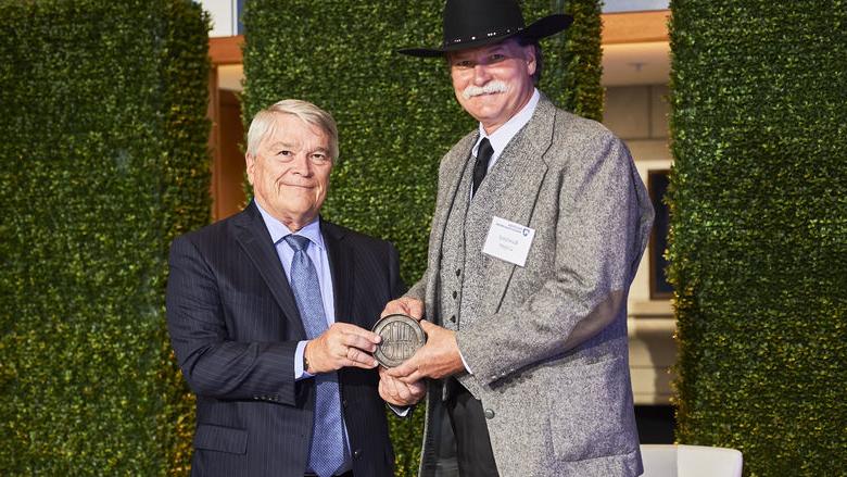 Rawland卡 accepts his 校友 Fellow award from Penn State President Eric Barron.  